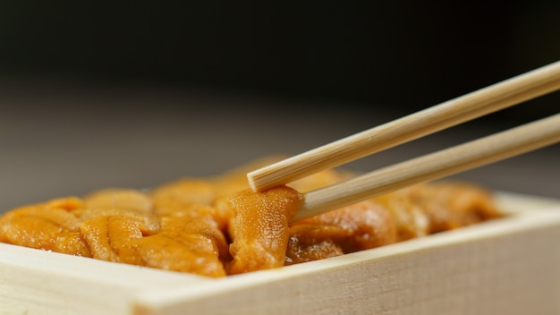 Uni-Sushi in Stäbchen. Seeigel (Uni Sashimi), japanisches Essen.