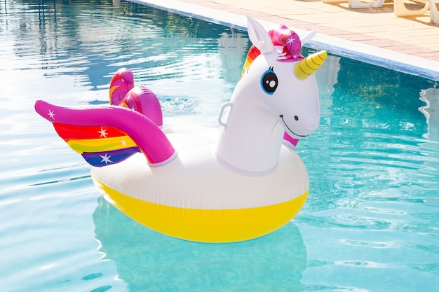 Unicornio colorido inflable en la piscina