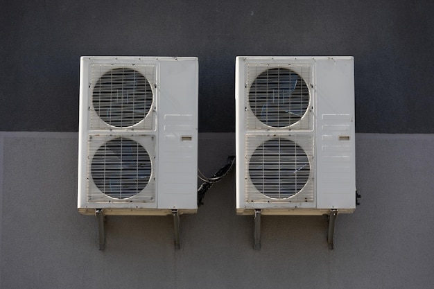 Unidad de aire acondicionado exterior con intercambiador de calor colgando fuera del edificio