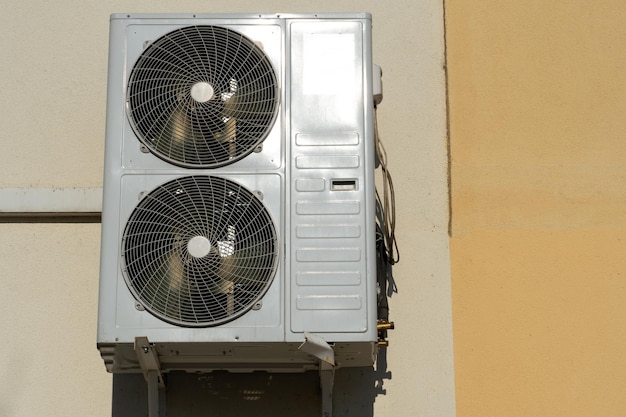 Una unidad de aire acondicionado exterior que consta de dos ventiladores Un gran acondicionador de aire industrial en la pared de una tienda o empresa Reparación y mantenimiento del sistema de aire acondicionado