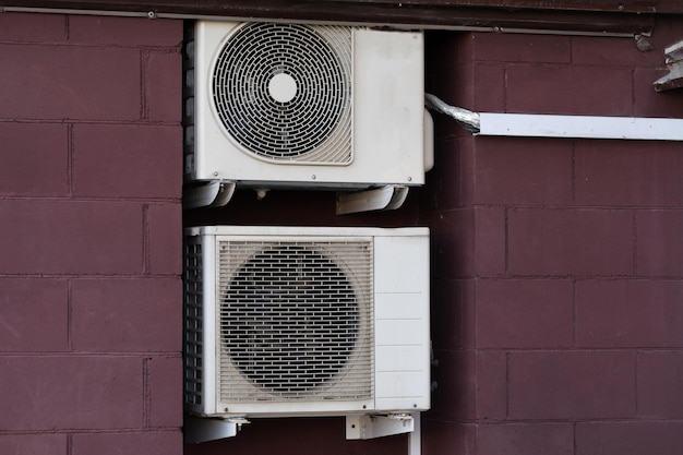 Unidad de aire acondicionado sistema split central colgando fuera del edificio