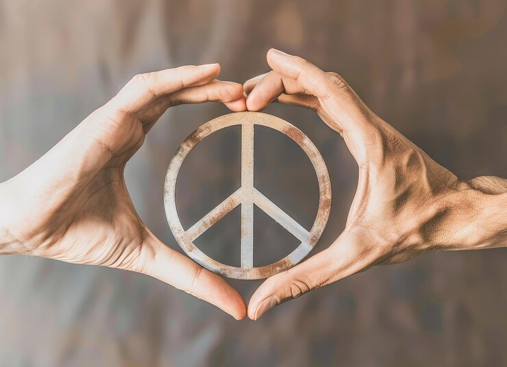 Unidad y amor por el Día Internacional de la Paz Manos formando corazones alrededor del símbolo de la paz con espacio de copia en la profundidad del campo