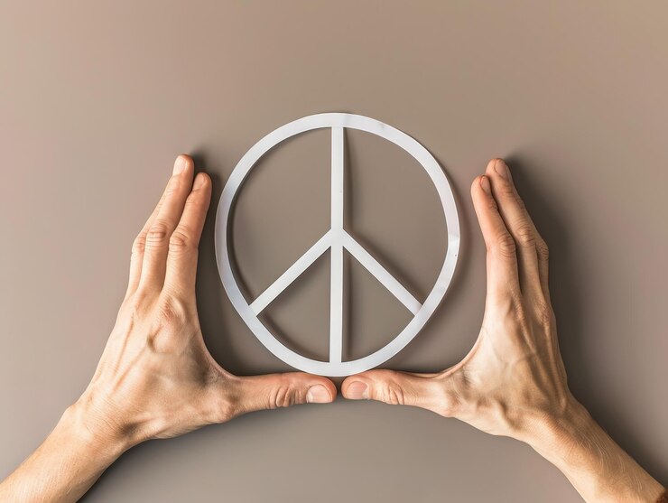 Unidad y amor Manos creando forma de corazón alrededor del símbolo de la paz en el Día Internacional de la Paz con Copy Space Profundidad de campo