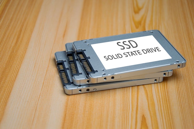 Foto una unidad de disco ssd colocada en una superficie de madera con un puerto ssd sata de alta velocidad.