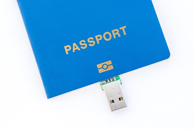 Unidad flash USB y pasaporte azul sobre un fondo blanco.