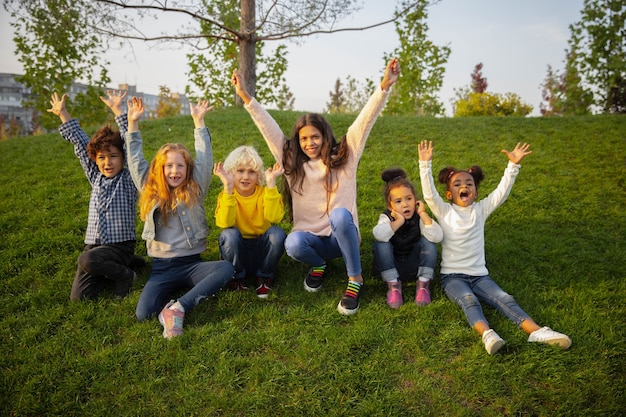 Unidad. Grupo interracial de niños, niñas y niños jugando juntos en el parque en verano. La amistad no tiene raza. Felicidad, infancia, educación, concepto de diversidad. Luce feliz y sincero.