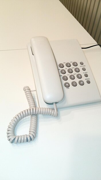 Una unidad telefónica blanca en la mesa