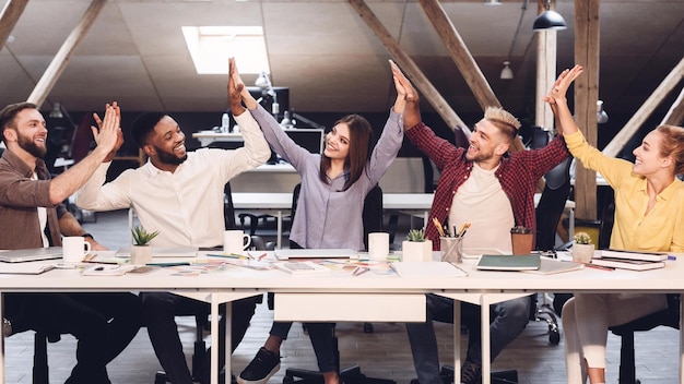 Foto unidad y trabajo en equipo diseñadores chocando los cinco entre sí