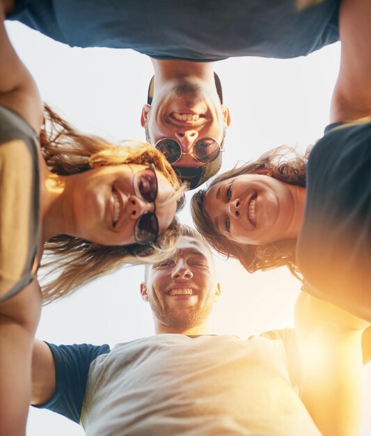 Foto unidos en amistad toma de ángulo bajo de un grupo de jóvenes amigos felices posando afuera