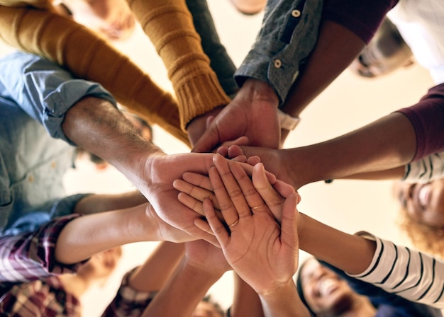 Uniendo sus fortalezas en unidad Toma en ángulo bajo de un grupo de personas uniendo sus manos