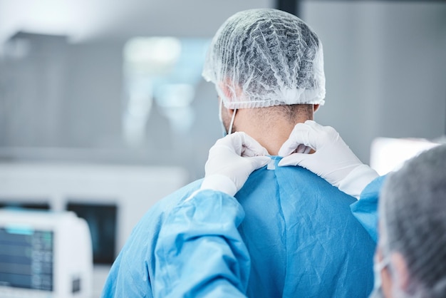 Uniforme de cirurgião e roupas de teatro para operação cirúrgica ou assistência médica Enfermeira ajudando médico com jalecos de segurança na sala de cirurgia de emergência hospital e medicina de apoio ao bem-estar ou risco