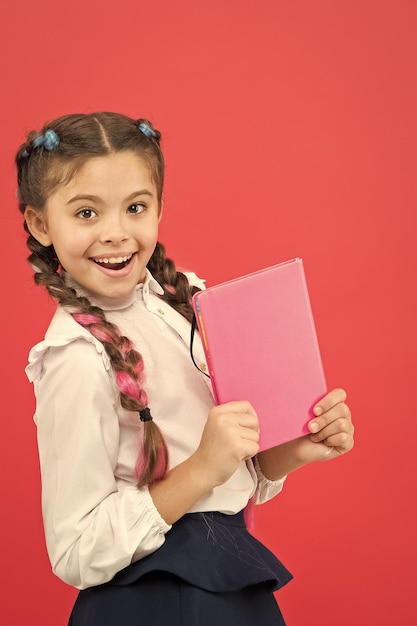 Uniforme escolar infantil segura livro Admirador de artigos de papelaria Colegial mostra bloco de notas Conceito de material escolar Artigos de papelaria escolares Compre artigos de papelaria bonitos para se divertir estudando Meninas famosas pela obsessão por artigos de papelaria