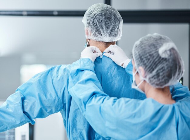 Uniforme médico e roupas de teatro para operação cirúrgica e assistência médica Enfermeira ajudando cirurgião com jalecos de segurança eppe hospitalar e sala de cirurgia de emergência na clínica para trabalho em equipe de medicina