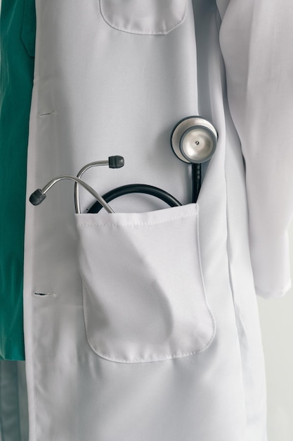 Uniforme médico con estetoscopio de metal y caucho en el bolsillo durante el día