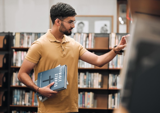 Universidad bíblica o estudiante en una biblioteca para investigar el conocimiento de la religión espiritual, la oración o el cristianismo en la estantería.