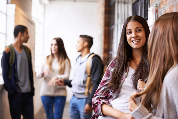 Universidade de amigas e pessoas do corredor conversando com vínculos de felicidade ou discussão juntos Faculdade adolescente ou comunicação escolar de jovens estudantes da geração z no campus para educação e aula