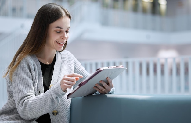 Universidade feliz ou mulher na biblioteca no tablet para educação em pesquisa ou aprendizado Aluno de maquete ou garota em tecnologia para pesquisa de comunicação de bolsa de estudos ou planejamento de projeto escolar no campus de colagem