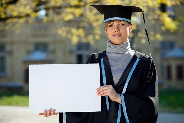 Universitätsabsolvent mit einem leeren Blatt in der Hand