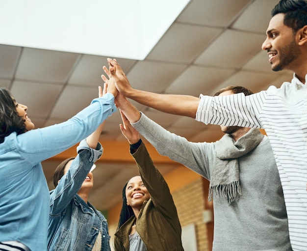Universitätsstudenten und Bibliothek mit High Five und glücklich aus Gruppenprojekt Erfolg mit Sieg College Bildungszentrum und Freunde mit Vereinbarung und Menschen Lächeln aus Leistung mit Vielfalt