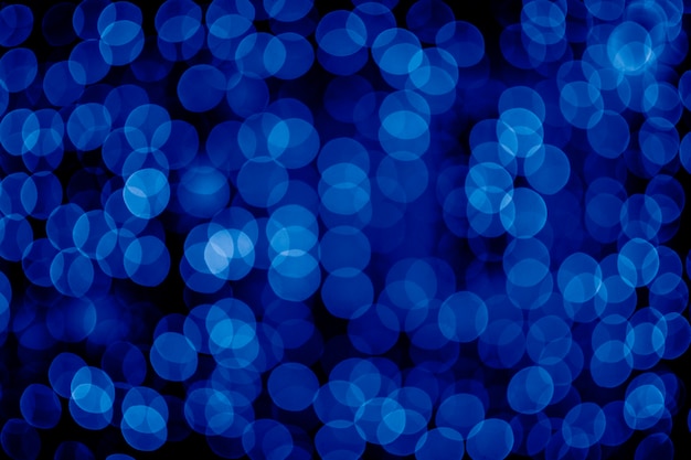 Unscharfer abstrakter blauer Hintergrund mit Bokeh, defokussierte Weihnachtsbeleuchtung. Urlaub Weihnachten Konzept. Trendfarbe des Jahres 2020.