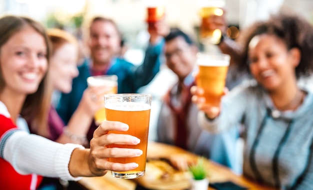 Foto unscharfer hintergrund von freunden, die bier auf der terrasse des brauerei-bar-restaurants trinken und rösten?