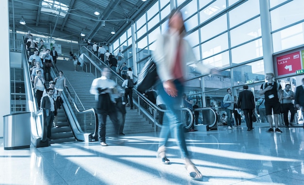 Unscharfer Messebesucher über eine Skywalk-Treppe