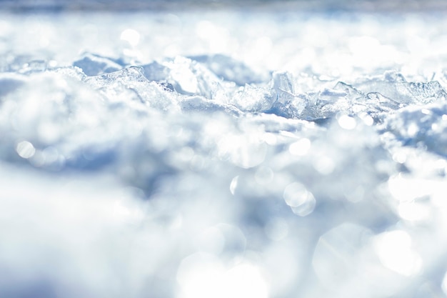 Unscharfer natürlicher Hintergrund Eisscholle, die gegen glitzernde Eiskristalle des Ufers auf der Oberfläche aufbricht