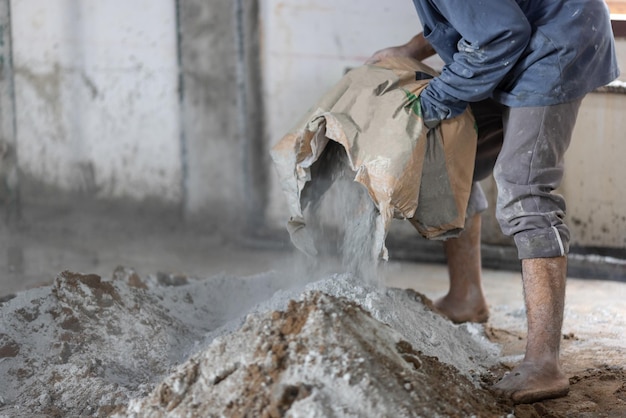 Unsicherer Bau von Wanderarbeitern aus Myanmar beim Gießen von Betonplatten auf der Baustelle