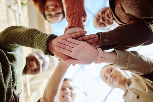 Foto unten hände stapeln und studentengruppe zur motivationsunterstützung oder bildung im sommersonnenschein vielfalt hand zusammen und lernen mit teamarbeit studieren oder stipendium an der universität für die zukunft