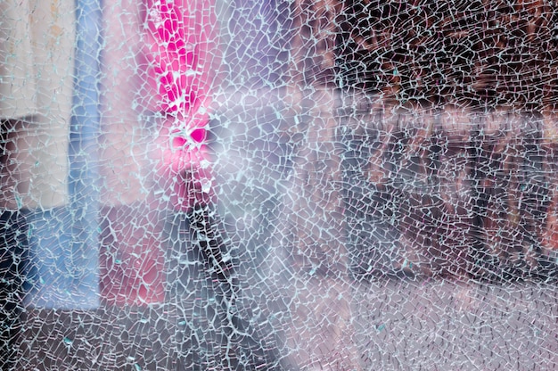 Unterbrochenes Glas eines Shopfensters eines Bekleidungsgeschäftes mit unfocused Hintergrund