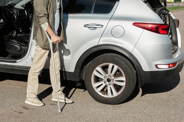 Unterer Abschnitt Aufnahme eines nicht erkennbaren Mannes mit Kupplung mit dem Auto auf dem Parkplatz im Freien Kopienraum