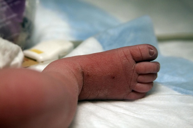 Foto unterer teil des auf dem bett liegenden babys