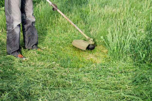 Foto unterer teil des mannes, der auf dem gras arbeitet