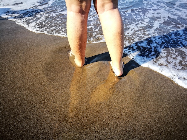 Foto unterer teil einer frau, die am strand steht