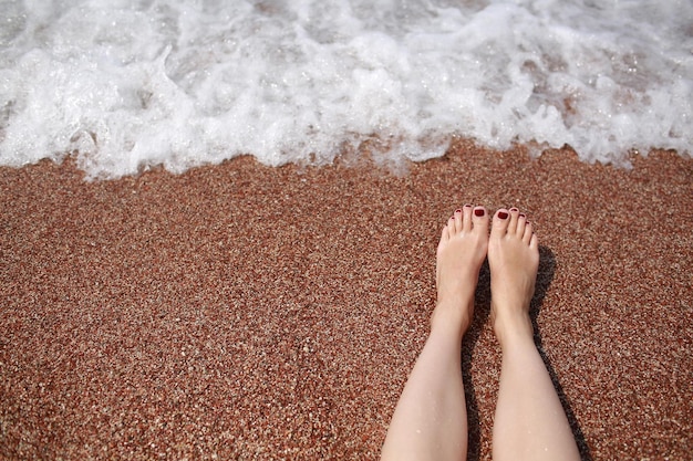 Foto unterer teil einer frau, die am strand steht