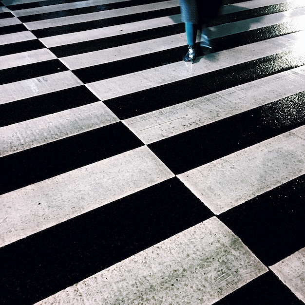 Foto unterer teil einer frau, die auf einem zebrastreifen steht