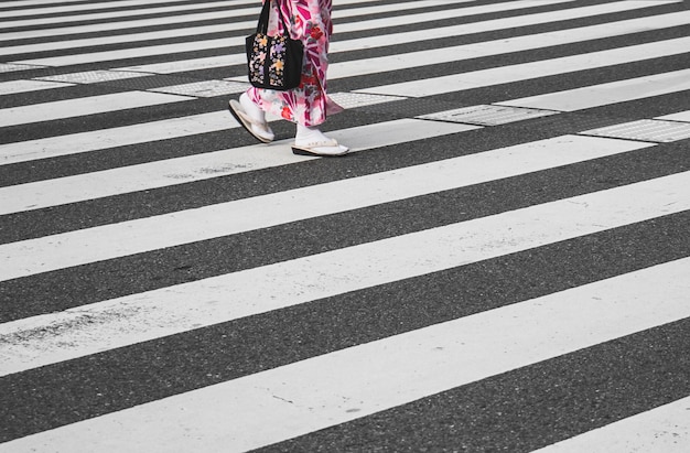 Unterer Teil einer Frau, die auf einer Zebrastrecke geht