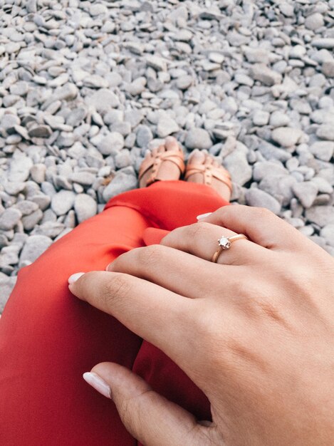 Foto unterer teil einer frau, die einen ring am strand trägt