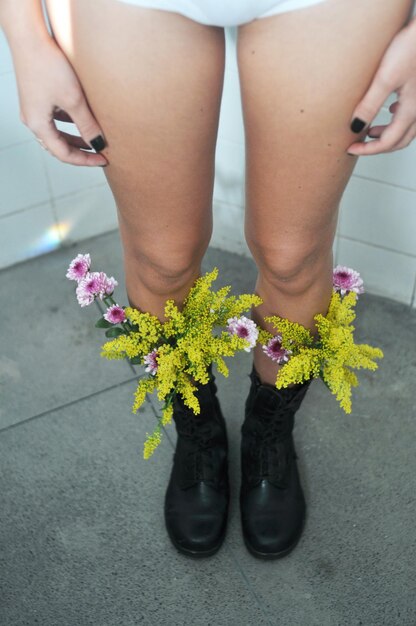 Foto unterer teil einer frau mit einem blumenstrauß