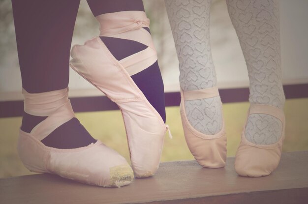 Unterer Teil einer Frau und eines Mädchens, die Ballettschuhe tragen