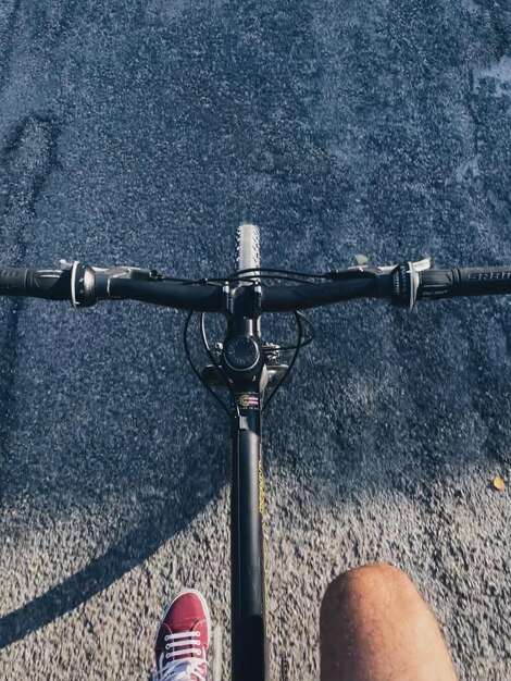 Foto unterer teil einer person, die fahrrad auf der straße fährt