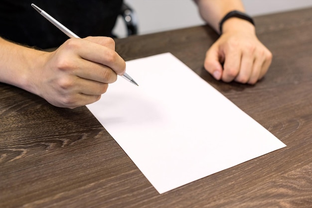 Foto unterer teil einer person, die papier gegen den tisch hält