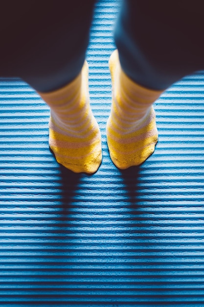 Foto unterer teil einer person, die socken trägt und auf dem boden steht