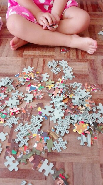 Foto unterer teil eines kindes, das mit einem puzzle spielt