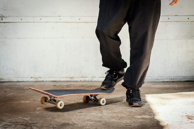 Foto unterer teil eines mannes, der auf einem fußweg skateboard fährt