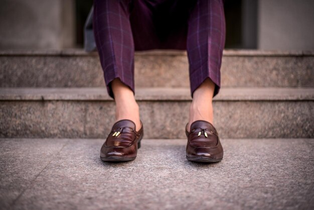 Foto unterer teil eines mannes, der auf einer treppe sitzt