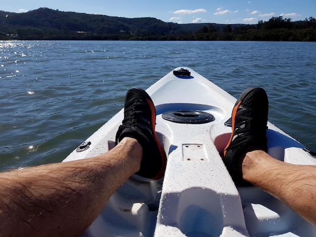 Foto unterer teil eines mannes in einem boot am fluss