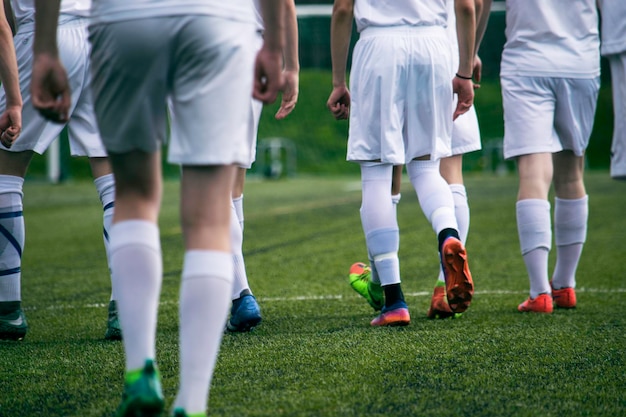 Unterer Teil von Fußballspielern, die auf dem Spielfeld laufen