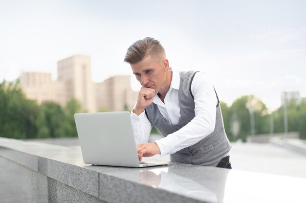 Unternehmen. Geschäftsmann, Der Im Freien Laptop Verwendet. Ernsthafte nachdenkliche kaukasische männliche Geschäftsperson Computer außerhalb des modernen Technologiekonzepts junger Erwachsener Manager Krise denken Problem Idee?