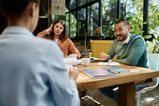 Unternehmensteam diskutiert Ideen für Startup-Projekte über Treffen in einem umweltfreundlichen Coworking Space